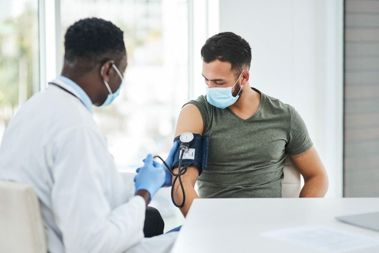 Un médecin mesure la pression artérielle d'un patient dans une clinique.